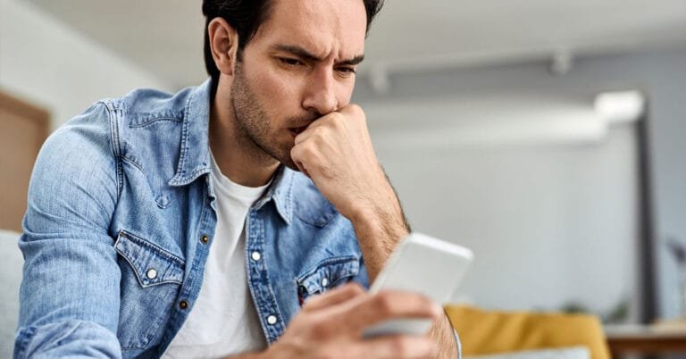 sinais de alerta ao contratar crédito: pessoa desconfiada analisando proposta suspeita no celular