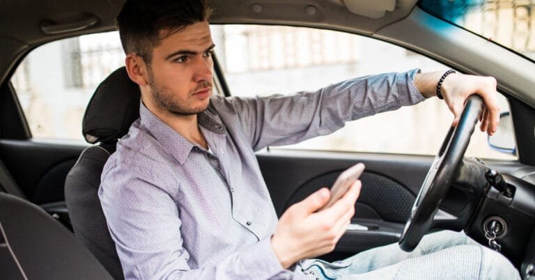 Pessoa contratando empréstimo online com garantia pelo celular, sem sair do carro