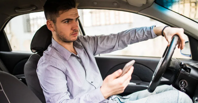 Pessoa contratando empréstimo online com garantia pelo celular, sem sair do carro